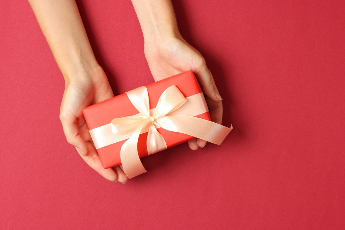 Frauenhände präsentieren ein Geschenk